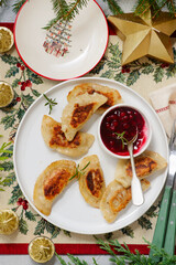 Traditional Polish fried pierogi with duck and cranberry sauce on a plate..style hugge.