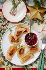 Traditional Polish fried pierogi with duck and cranberry sauce on a plate..style hugge.
