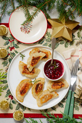 Traditional Polish fried pierogi with duck and cranberry sauce on a plate..style hugge.