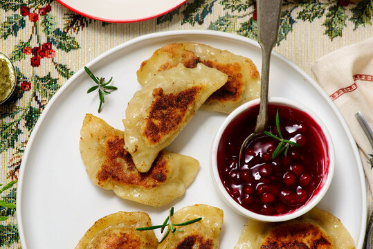 Traditional Polish fried pierogi with duck and cranberry sauce on a plate..style hugge.