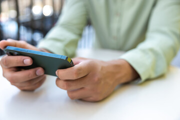Unrecognizable man using mobile phone playing video games outdoor