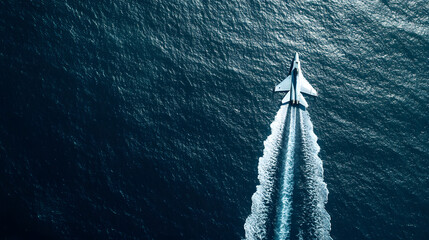 A fighter jet skimming above the ocean surface during a low-altitude test flight.