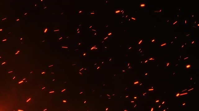 Bright hot fire sparks moving fast with the wind surrounded by smoke and blaze. Fire particles rising up. Big firestorm, wildfire, and disaster. Burning bonfire ashes closeup. Glowing fire embers. 4k.