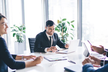 Cheerful employees sitting at meeting table having conference brainstorming for discussing business ideas and create startup strategy for progressive project, successful colleagues collaborating