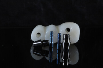 In dental and cosmetic dentistry, bone-anchored dental implant treatment with porcelain bridge prostheses and implant screws.  © UniqDream