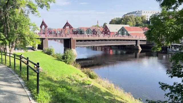 Tourists enjoying their walk on gamla bybron bridge in trondheim, norway, on a sunny summer day