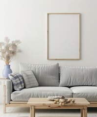A minimalist living room with a grey sofa. wooden coffee table. and a blank frame on the wall