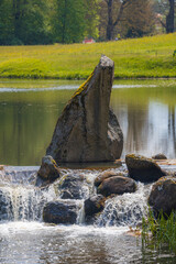Tranquil Stream with Cascading Water over Rocks in a Lush Green Landscape