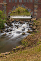 Serene Cascading Stream Flowing Through Scenic Stone Arch Bridge