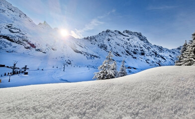 Winter mountain scene with clear skies and snowy trees.