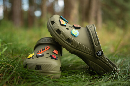 Warsaw, Poland - July 29, 2024: pair of green Crocs sneakers with the Jibbitz logo outdoors.