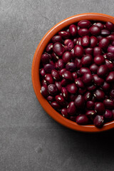 Earthenware bowl full of red beans from Anguiano on a kitchen worktop in a zenithal photograph.