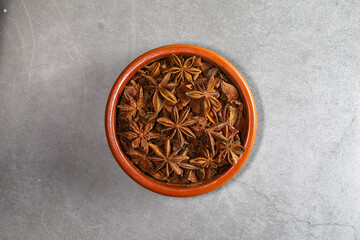A clay bowl full of Anis on a kitchen countertop in a zenithal photograph