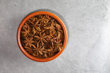 A clay bowl full of Anis on a kitchen countertop in a zenithal photograph