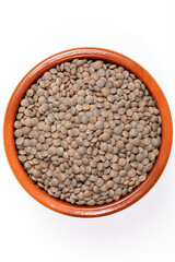 Earthenware bowl full of lentils on a white background in an zenithal photograph
