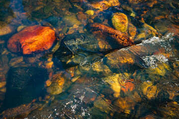 Colorful rocks under the flowing water of the Pecos River, New Mexico