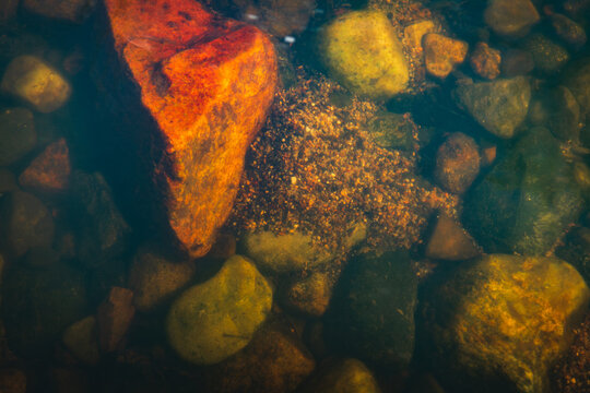 A bed of gravel in the lee of a colorful boulder under the waters of the Pecos River, New Mexico