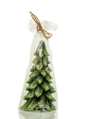 Decorative small green Christmas tree in a plastic wrap on white reflective background. Present idea. Getting ready for special season concept.