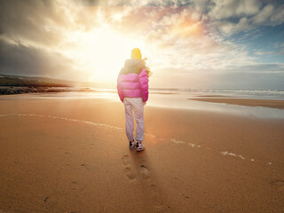 Teenager girl walking on stunning Fanore beach in county Clare, Ireland. Travel and tourism...