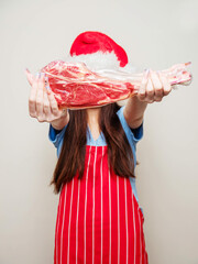 Young girl showing premium tomahawk steak in a plastic wrap. Fine food promotion and advertisement...