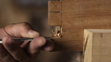 Close-up of a carpenter chiseling a mortise in wood for a multiple mortise and tenon joint. This detailed footage showcases the precision and craftsmanship involved in traditional woodworking - Powered by Adobe