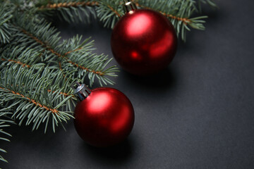 Composition with Christmas balls and fir branches on dark background, closeup