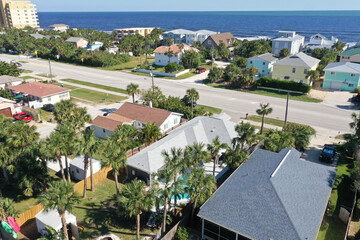 Aerial looking east over New Smyrna Beach, Florida neighborhoods, beachfront houses and the Atlantic Ocean.