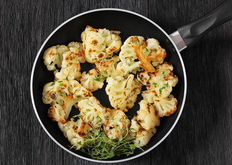fried cauliflower florets on a skillet, top view