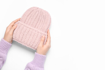 Female hands with knitted warm hat isolated on white background, closeup