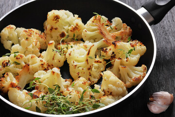 fried cauliflower florets on a skillet, top view