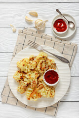 fried cauliflower florets on white plate, top view