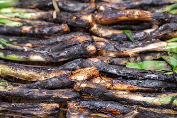 Close-Up of Calçots (long spring onions) Cooking to Perfection on the Grill.