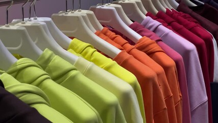 Rainbow Collection of Hoodies on Store Display, Trendy Sportswear in Vibrant Colors from Neon Yellow to Deep Blue, Modern Fashion Retail Shot