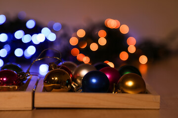 On Christmas Eve, festive Christmas balls were left on the table against the backdrop of Christmas lights