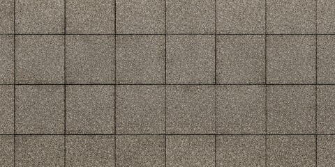 Fototapeta premium Tiles arranged in a grid pattern. Each tile is rectangular and has a textured surface with shades of gray and brown. The lines between the tiles are clearly visible, creating a net-like visual effect