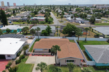 Aerial looking east over Daytona Beach Shores residential riverfront neighborhood in the foreground with Daytona Beach high rise condos and hotels in the background.