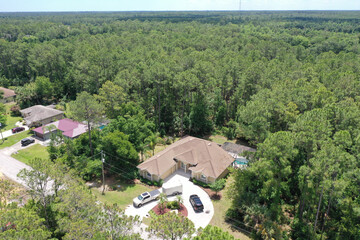 Aerial view  Florida forest with land cleared for a large Florida home featuring a circular drive and swimming pool, Palm Coast, Flagler County, Florida, USA. 