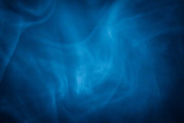 A close-up of soft, swirling blue smoke patterns creating an ethereal and dreamy abstract effect against a dark background