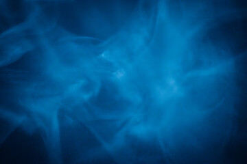A close-up of soft, swirling blue smoke patterns creating an ethereal and dreamy abstract effect against a dark background