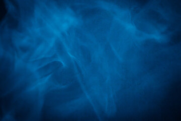 A close-up of soft, swirling blue smoke patterns creating an ethereal and dreamy abstract effect against a dark background