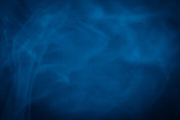 A close-up of soft, swirling blue smoke patterns creating an ethereal and dreamy abstract effect against a dark background