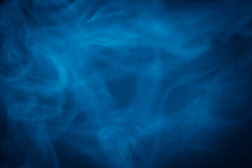 A close-up of soft, swirling blue smoke patterns creating an ethereal and dreamy abstract effect against a dark background