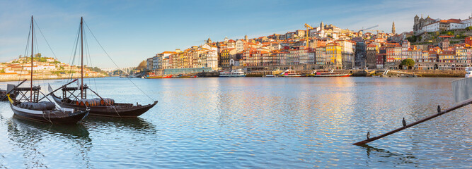 Traditional rabelo boats on the Douro River with the colorful Ribeira district in Porto, Portugal