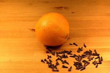 Cloves and orange. Wooden background. Christmas preparations and decorations. Swedish tradition.