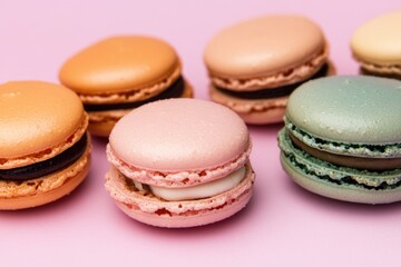 Fototapeta premium A selection of colorful macarons arranged on a bright pink surface, perfect for baking or food-related content