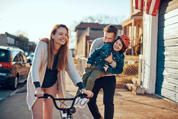 Obraz premium Young family having a walk through the suburbs