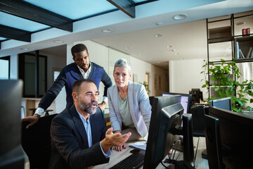 Colleagues collaborating on a computer project in a modern office environment