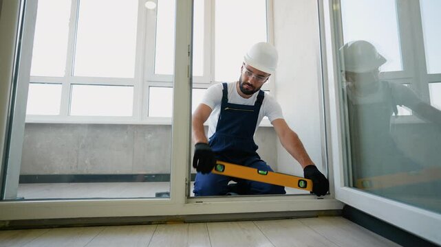 Worker Aligning PVC Door Frame with Level for Accurate Installation