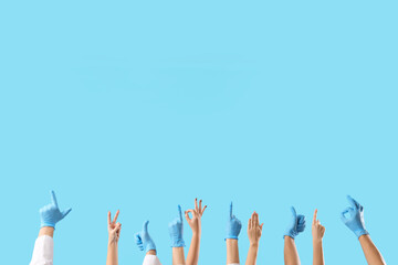 Gesturing hands of doctors on blue background