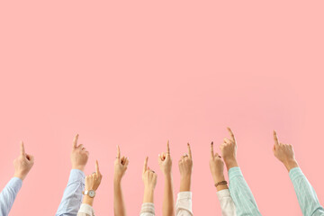 Many hands pointing at something on pink background